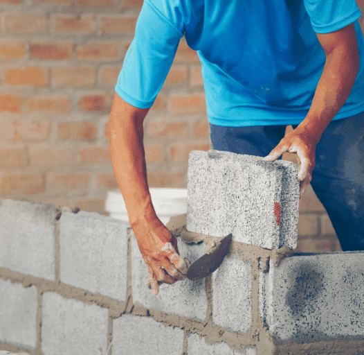 Albañil levantando pared con bloques en una reforma